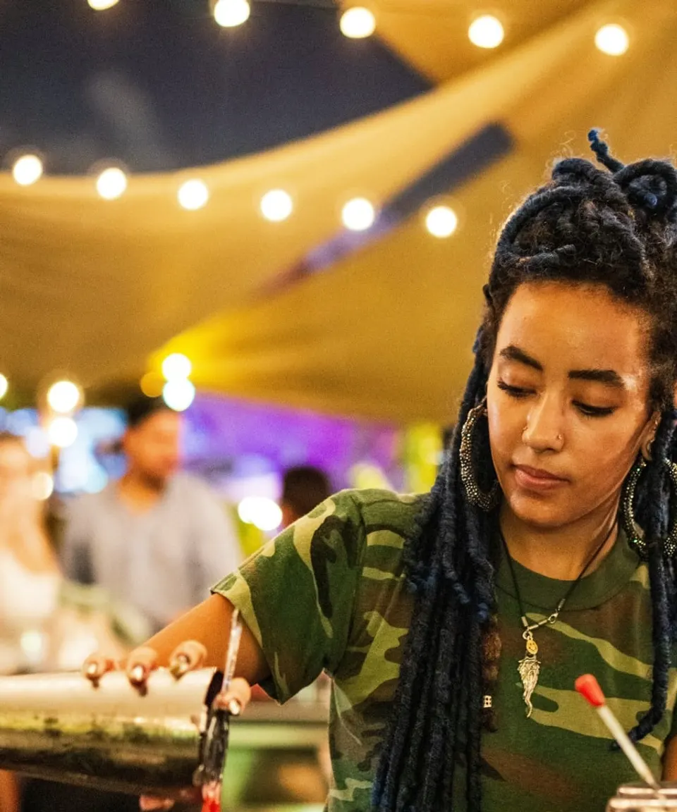 Bartender mixing a drink in the evening under string lights